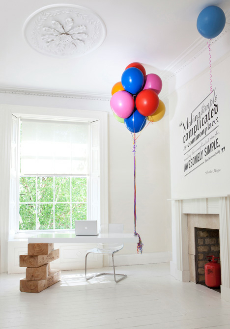 Original mostrador de recepción sostenido por bloques de madera y globos