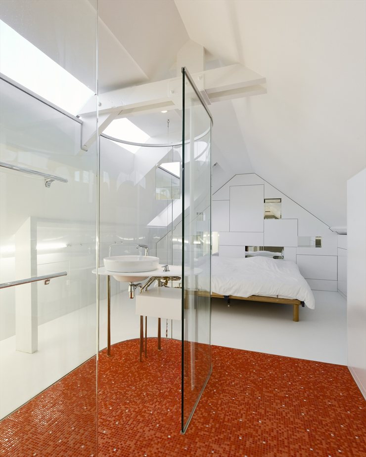 Habitación minimalista con baño de paredes de cristal