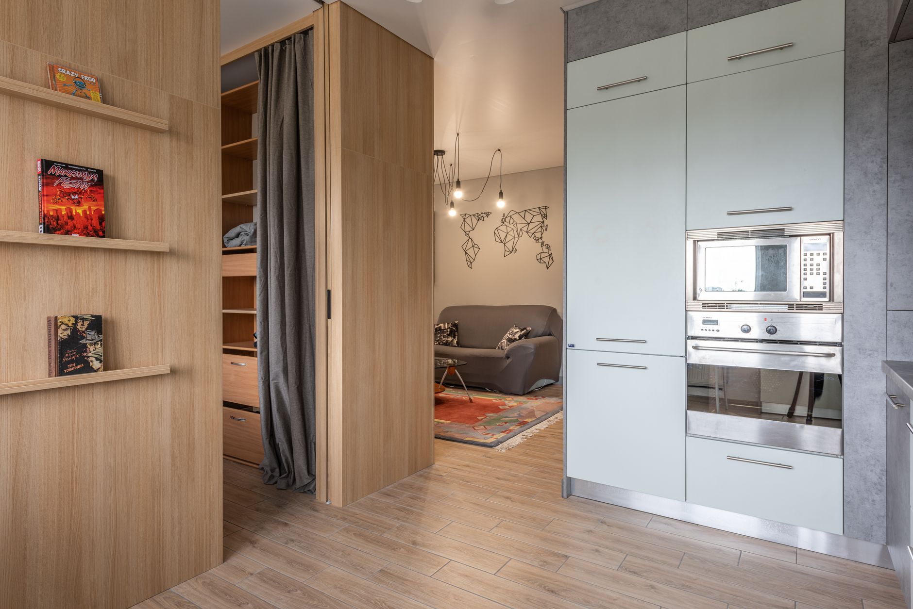 Una pared con estanterías flotantes y un sistema modular de almacenamiento vertical, optimizando el espacio en un apartamento pequeño.