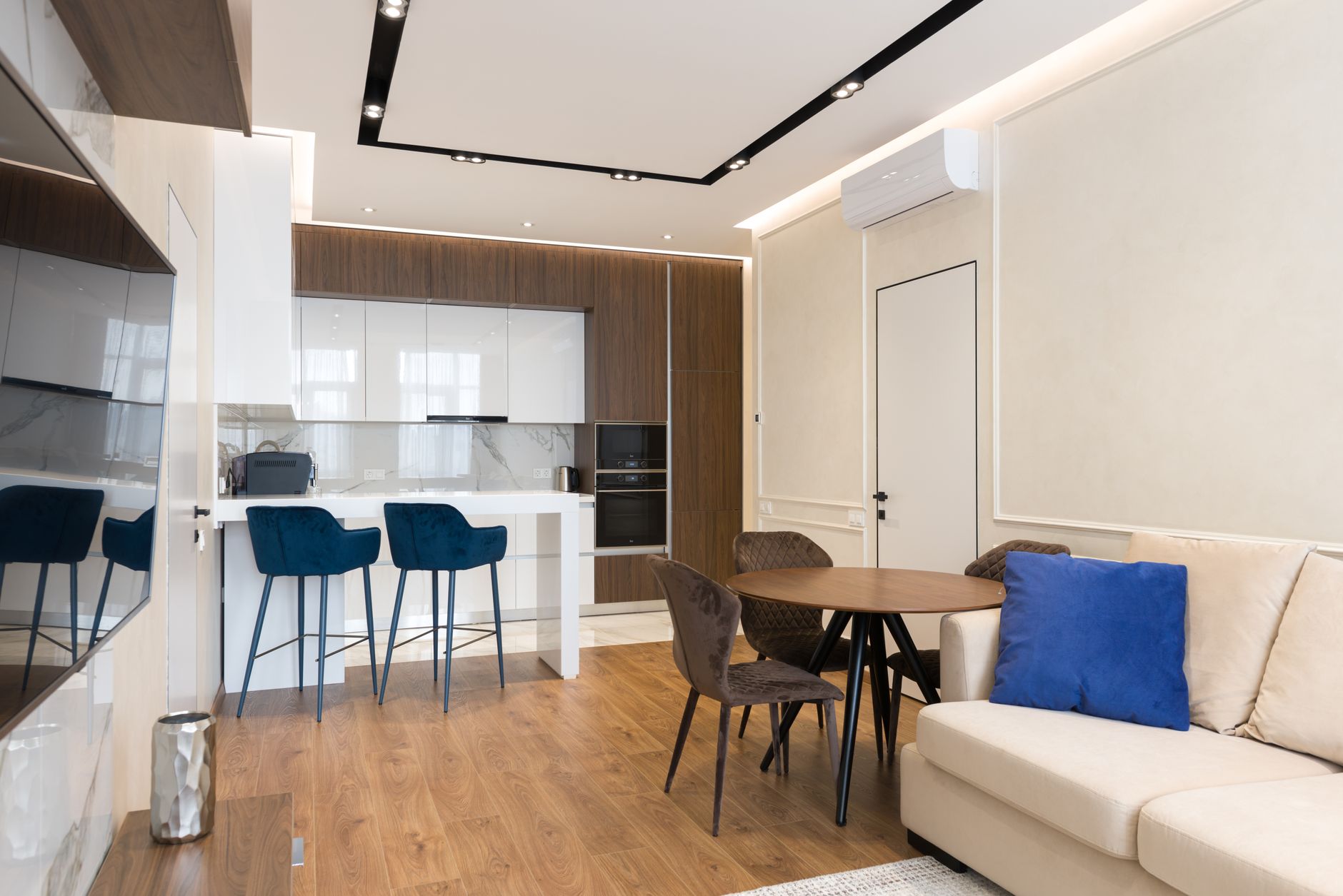 Un sofá cama moderno en un salón pequeño, con una mesa extensible que ahorra espacio, mostrando la versatilidad de los muebles multifuncionales.