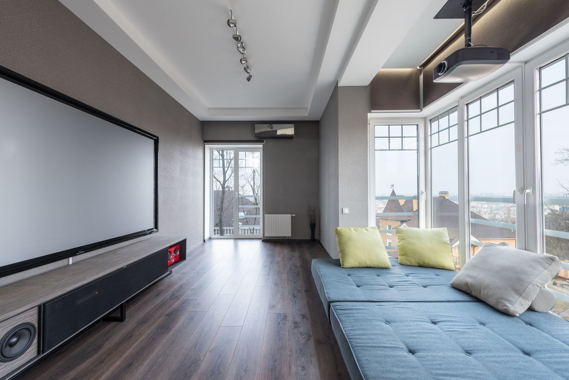 Un salón minimalista con una imagen proyectada en una pared blanca, creando una experiencia de cine en casa sin TV visible.