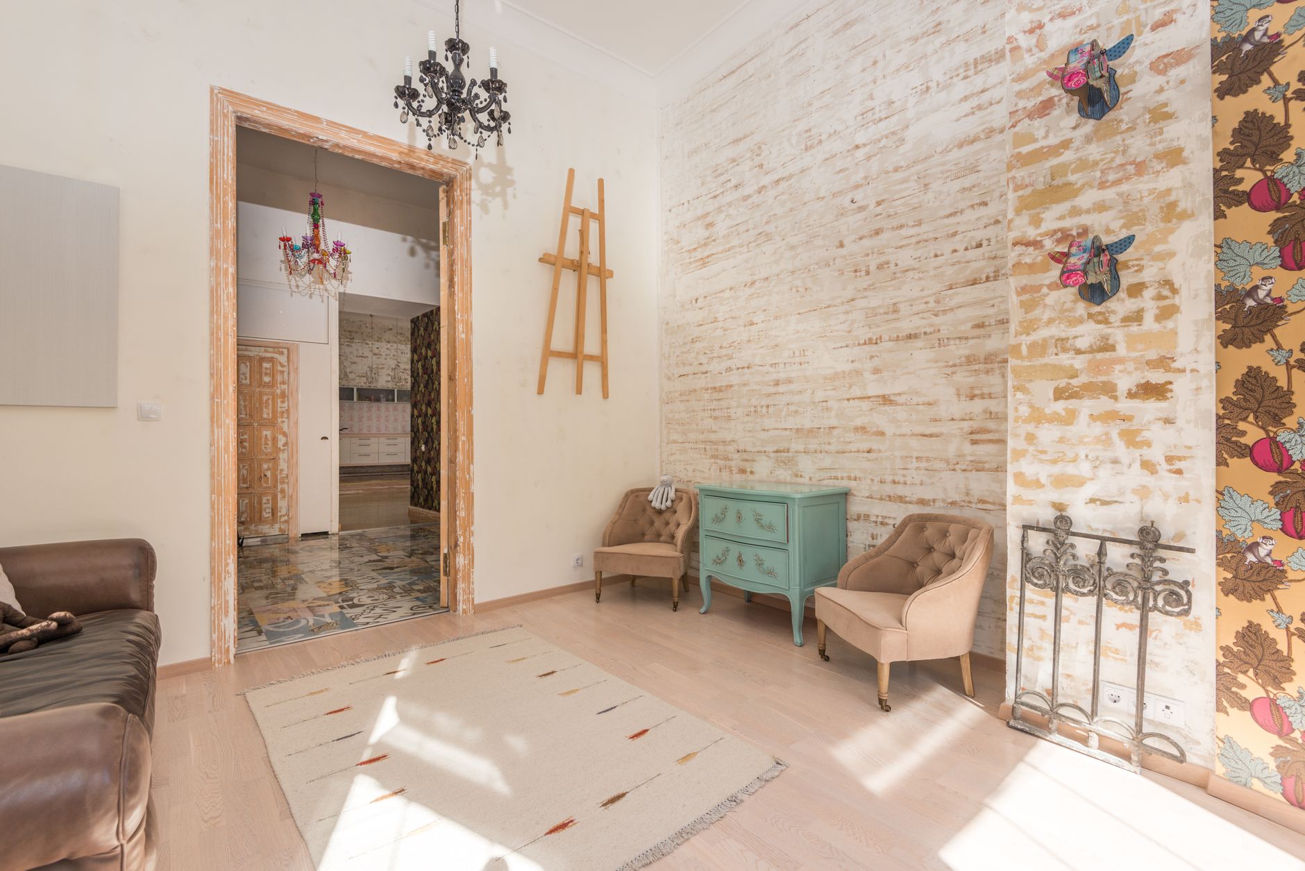 Salón con un estilo ecléctico, donde un sofá moderno contrasta con una mesa de centro vintage y otros elementos decorativos antiguos