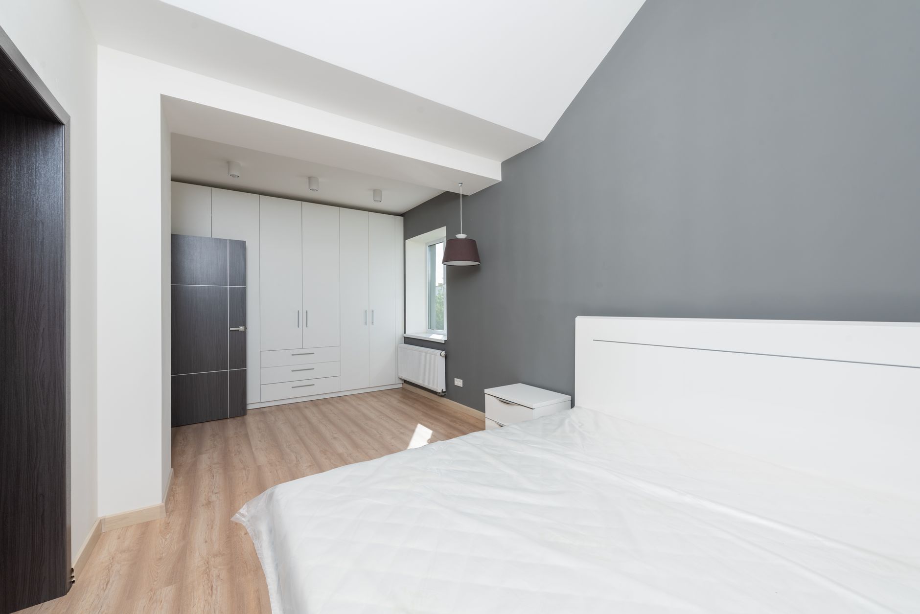 Soluciones de almacenamiento inteligente en una habitación, incluyendo estanterías verticales y muebles con espacio oculto, manteniendo el orden.