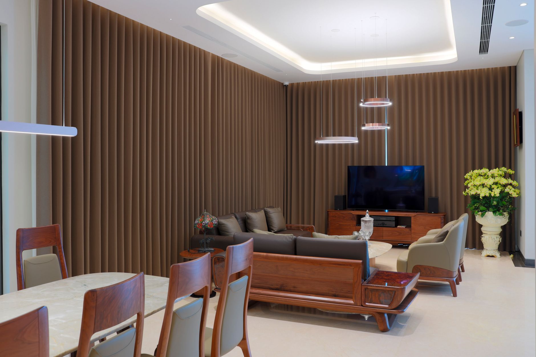Una sala de estar moderna con varias fuentes de luz encendidas, mostrando cómo la iluminación por capas crea diferentes ambientes.